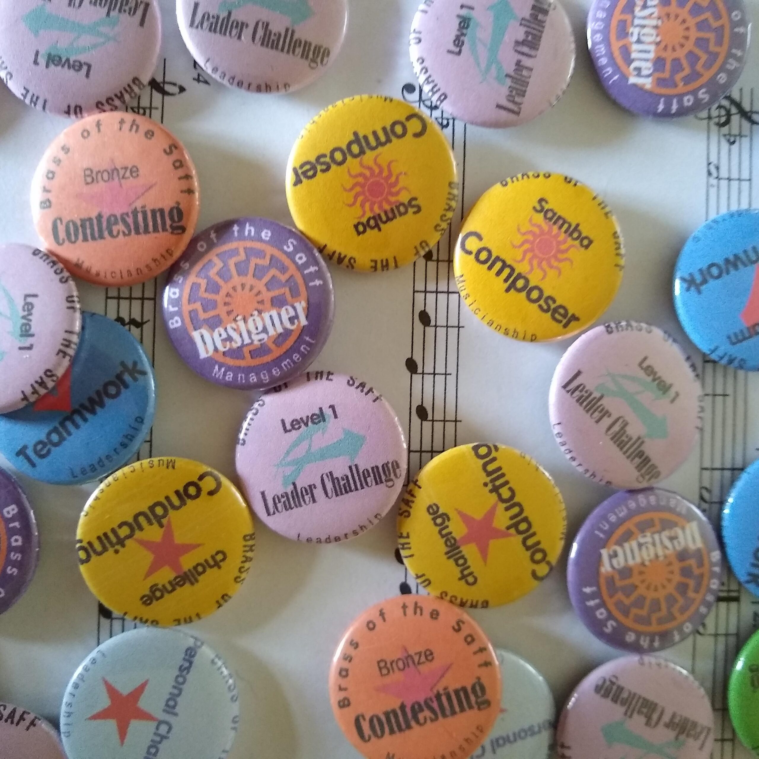 brightly coloured button badhes feature labels including composing, conducting and community